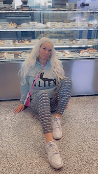 a woman sitting on the floor in front of a display of pastries